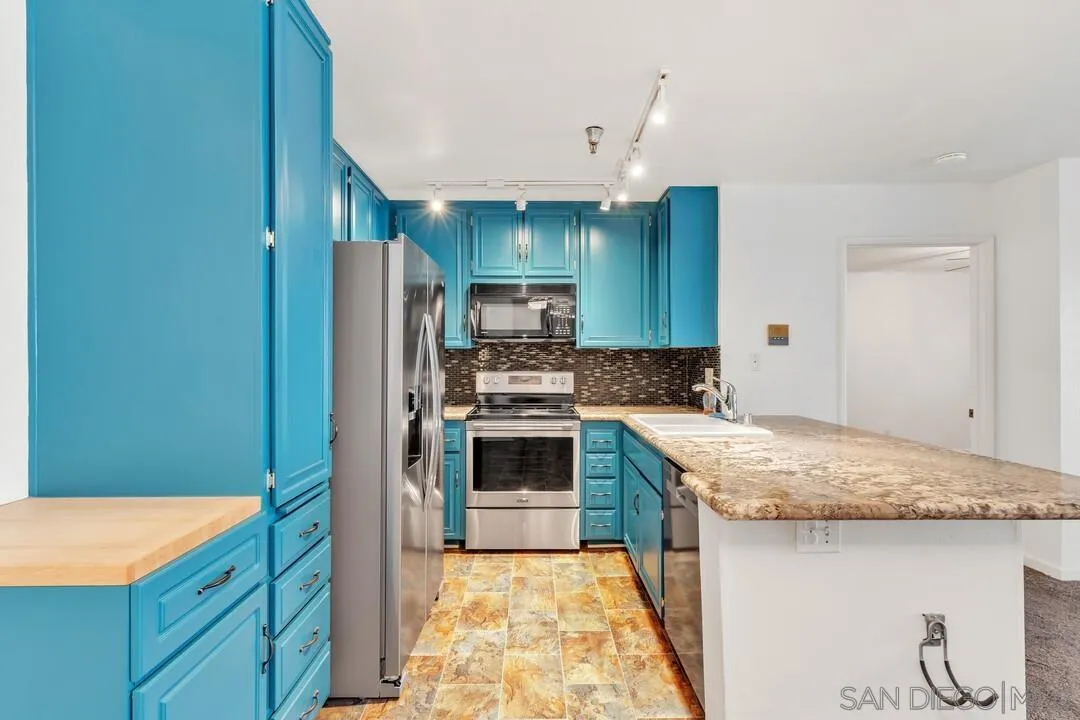 5745 Friars Road, Unit 104 San Diego, CA 92110 - Photo 15 of 38 a kitchen with granite countertop a sink stove and refrigerator