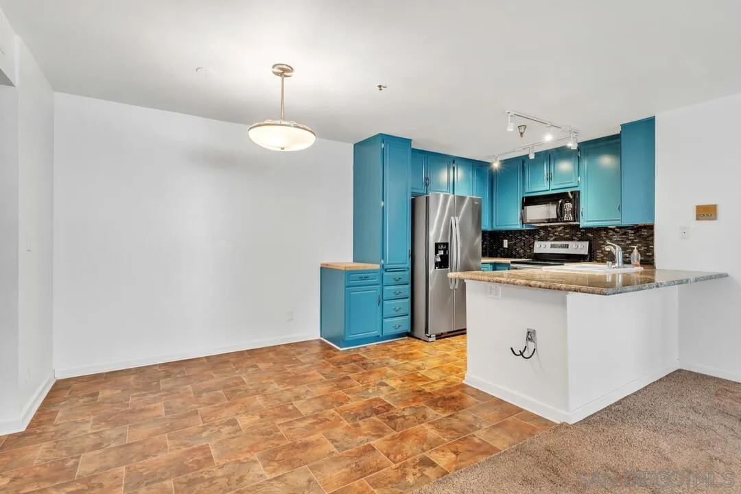 5745 Friars Road, Unit 104 San Diego, CA 92110 - Photo 5 of 38 a kitchen with stainless steel appliances a refrigerator and a stove top oven