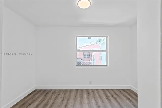 a view of a room with wooden floor and window