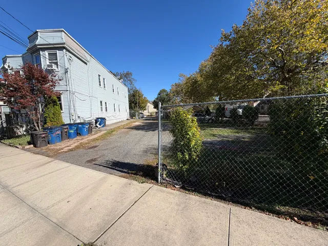 a view of a house with backyard and trees