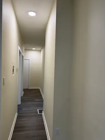 a view of a hallway with wooden floor