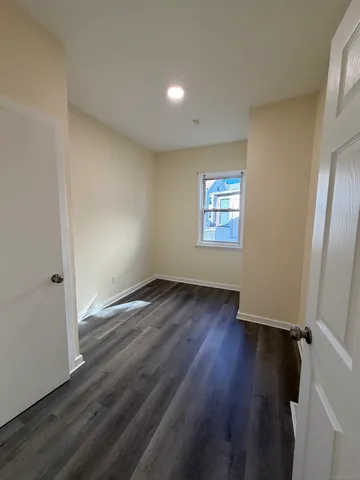 an empty room with wooden floor and window