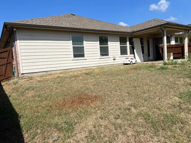 a view of a house with large windows and plants