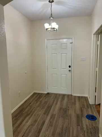 a view of a room with wooden floor and white walls