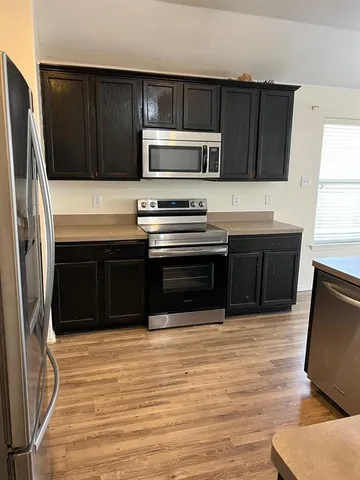 a kitchen with stainless steel appliances wooden cabinets and a sink