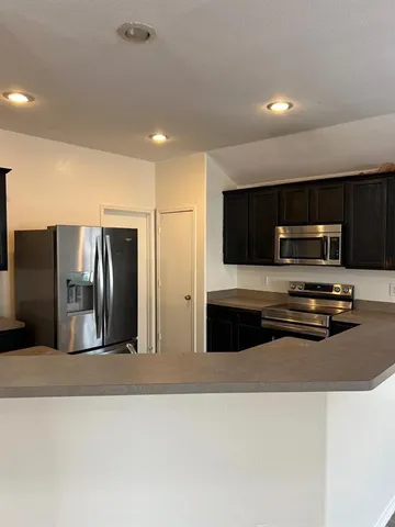 a kitchen with stainless steel appliances a refrigerator and a stove top oven