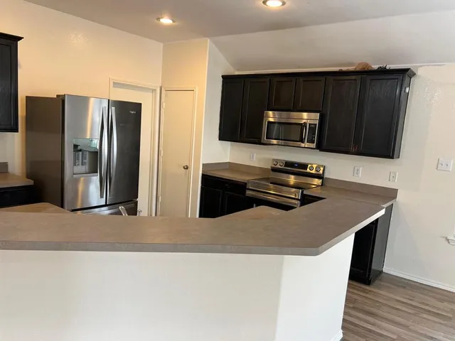 a kitchen with stainless steel appliances a microwave a sink and a refrigerator