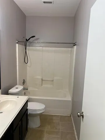 a bathroom with a granite countertop sink a toilet and shower
