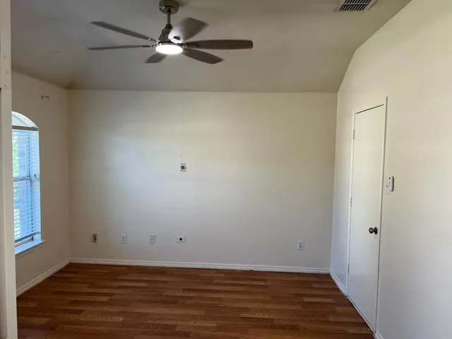 a view of a room with wooden floor and a window
