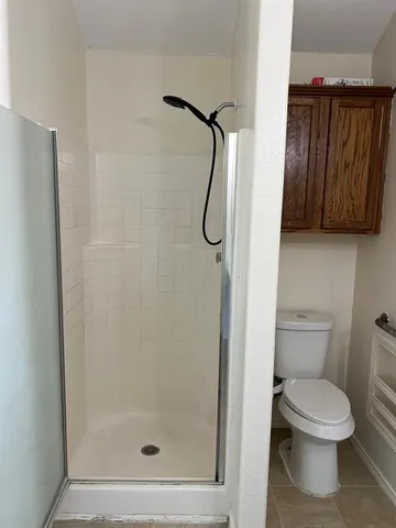 a bathroom with a toilet and a shower