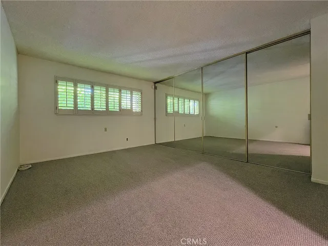 a view of an empty room with window and stairs