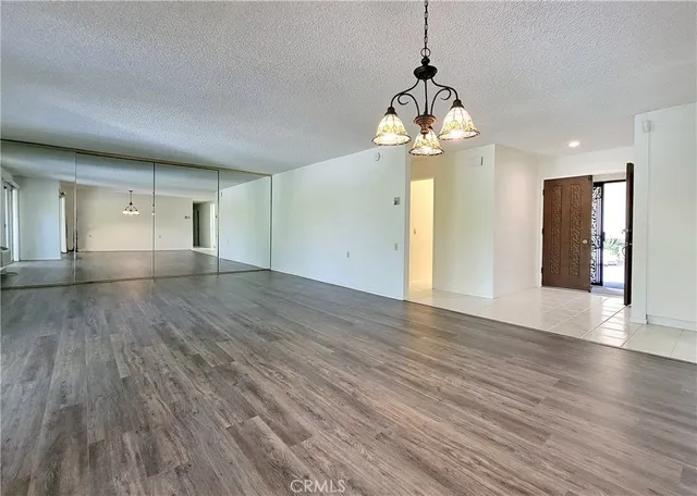 a view of an empty room with wooden floor and windows