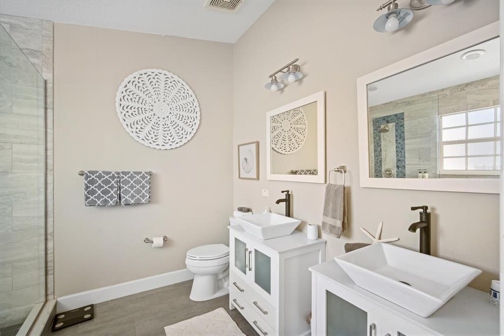 135 Bath Club Circle North Redington Beach, FL 33708 - Photo 20 of 45 a bathroom with a toilet a sink and a mirror