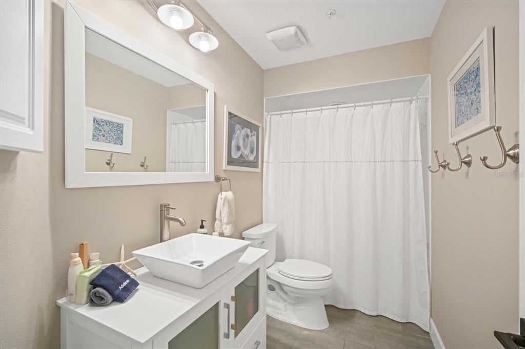 135 Bath Club Circle North Redington Beach, FL 33708 - Photo 23 of 45 a bathroom with a sink a toilet and a mirror