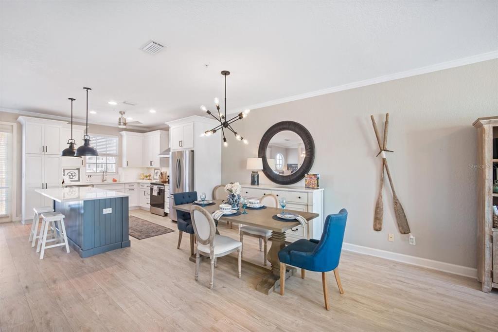 135 Bath Club Circle North Redington Beach, FL 33708 - Photo 8 of 45 a view of a dining room with furniture a chandelier and wooden floor