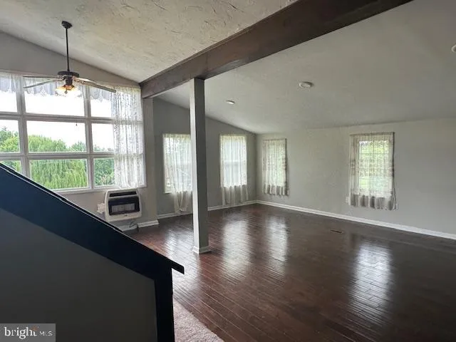 a view of a livingroom with wooden floor and a fireplace