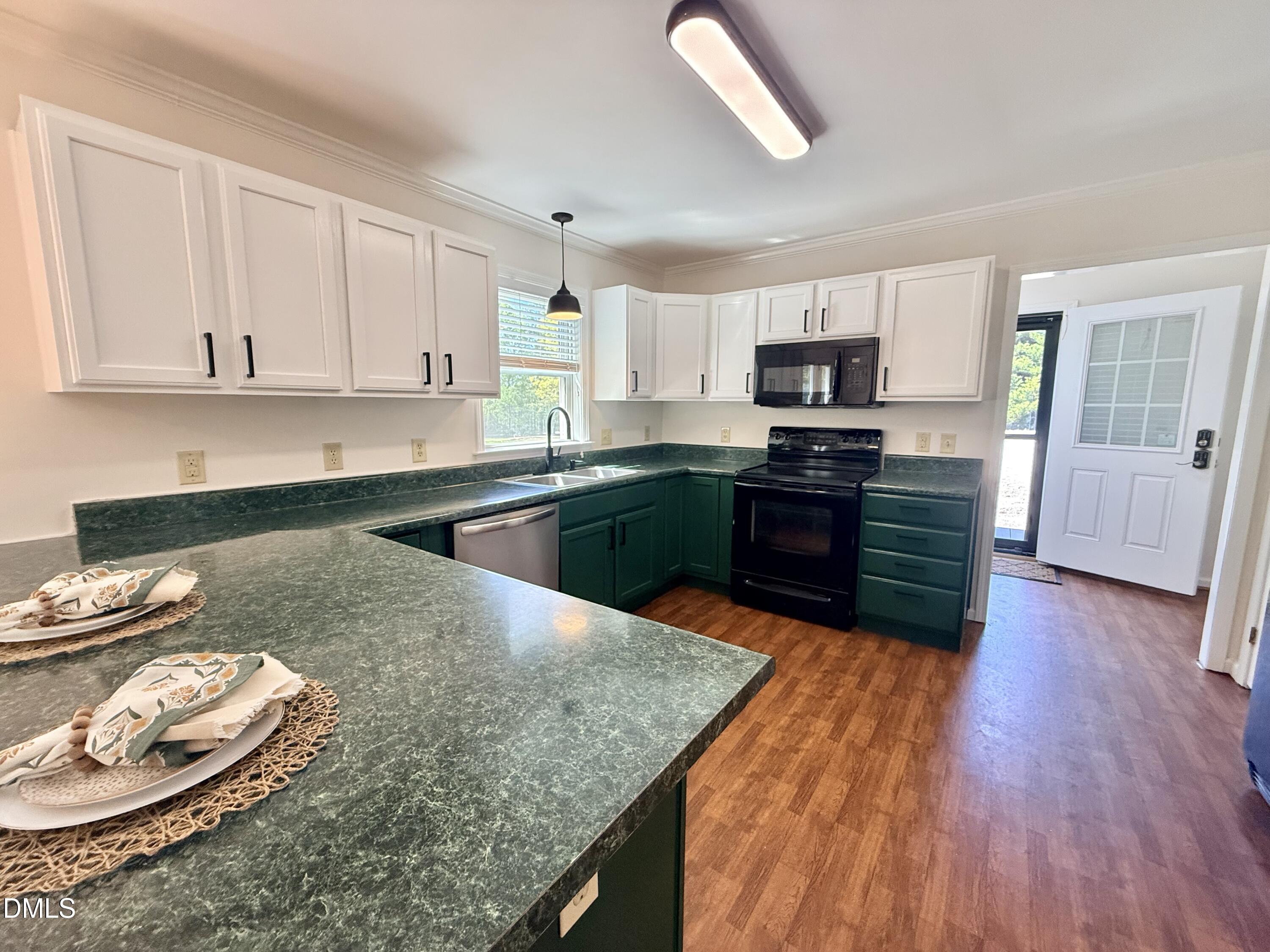 2429 Halifax Road Roxboro, NC 27573 - Photo 18 of 54 a kitchen with stainless steel appliances granite countertop a sink dishwasher stove and wooden floor