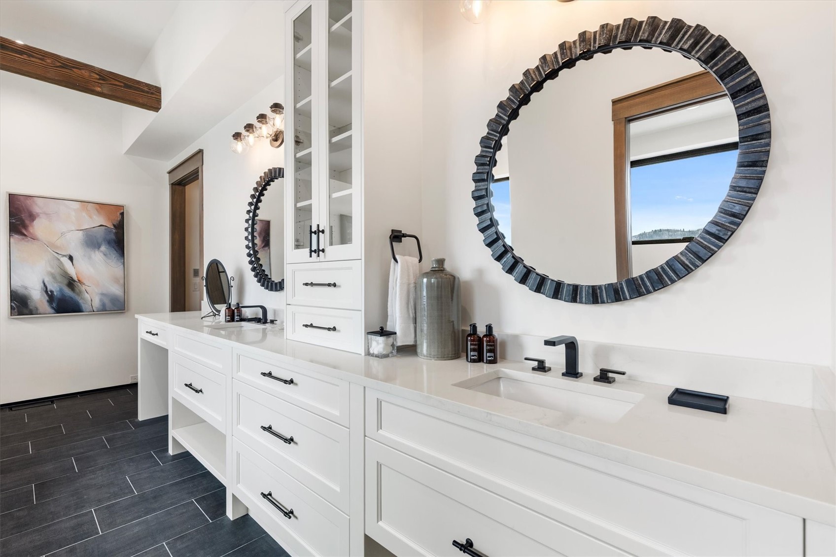 1855 Burgess Creek Road, Unit 4 Steamboat Springs, CO 80487 - Photo 26 of 42 Ensuite bathroom adjacent to the primary with dual vanities, mirrors, lighting, tile floors and quartz countertops. Sliding pocket door with mirror leads to a walk-in closet