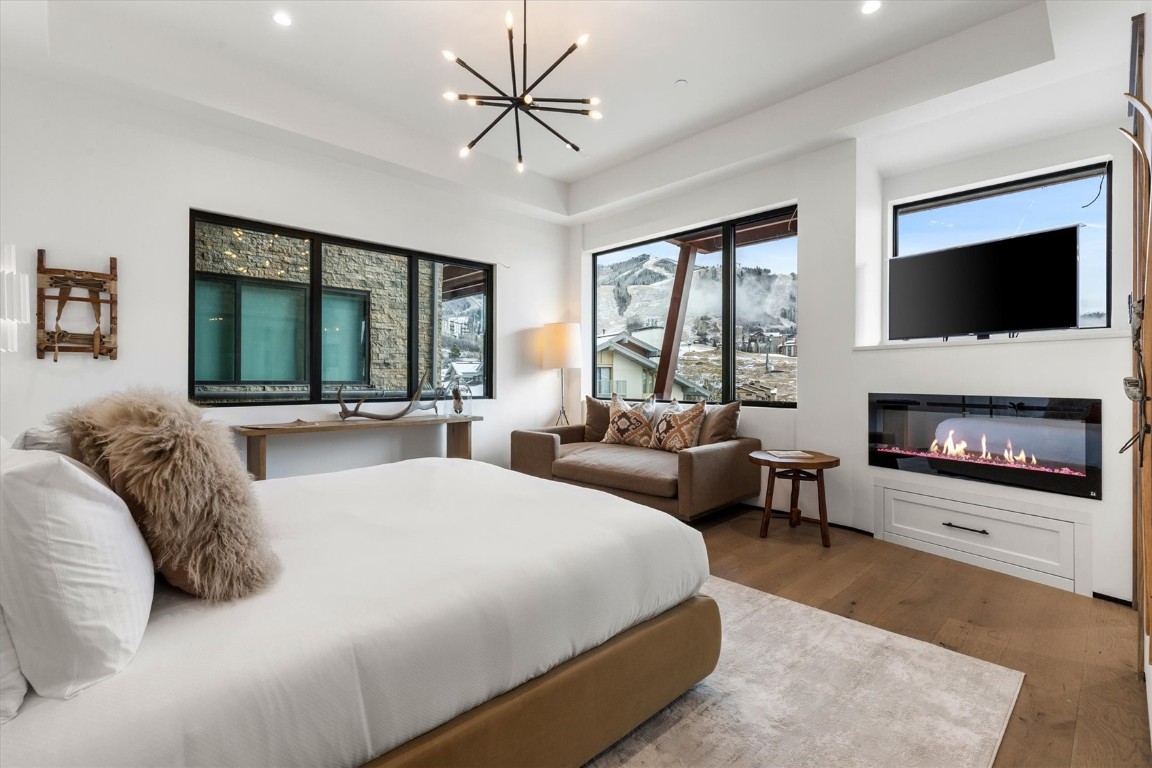 1855 Burgess Creek Road, Unit 4 Steamboat Springs, CO 80487 - Photo 6 of 45 a bedroom with a large bed and a fireplace