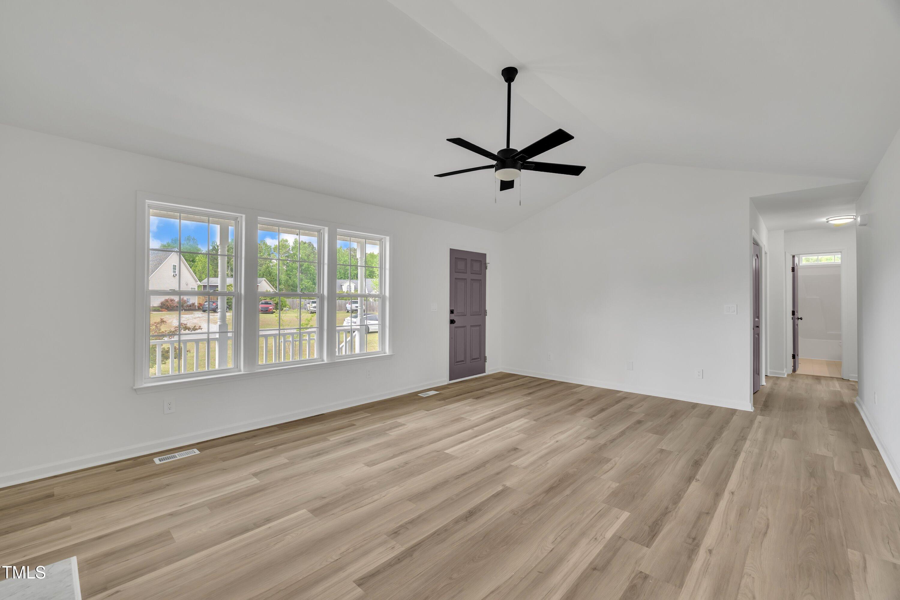112 Edmondson Drive Willow Spring, NC 27592 - Photo 12 of 32 a view of an empty room with a window and wooden floor