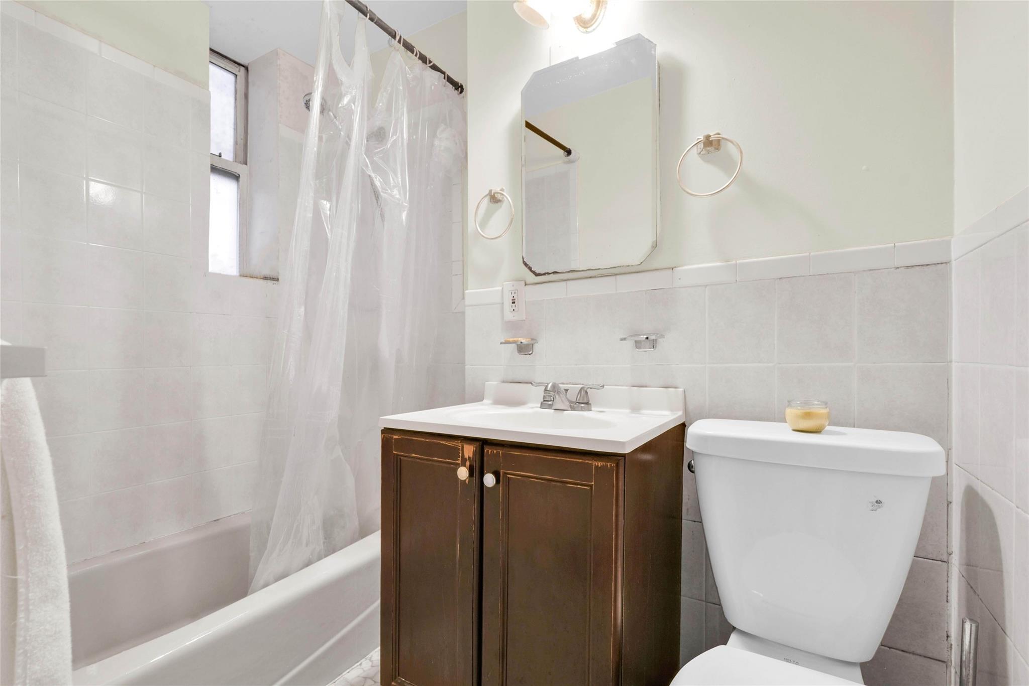 2146 Cortelyou Road, Unit 1R Brooklyn, NY 11226 - Photo 9 of 12 Full bathroom featuring toilet, vanity, shower / bath combo, wainscoting, and tile walls