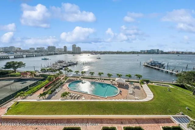 a view of a swimming pool with a yard and pool in the back
