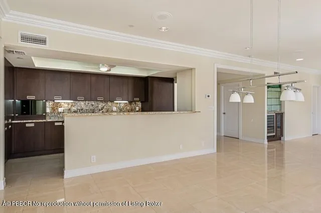 a large kitchen with kitchen island a large counter top and stainless steel appliances