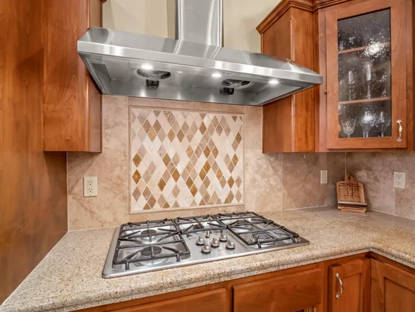 a kitchen with granite countertop wooden cabinets a sink a window and stainless steel appliances