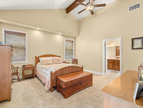 a bedroom with a bed and dresser with mirror