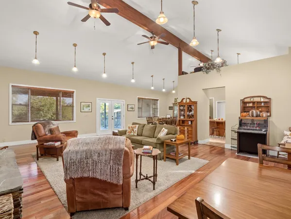 a living room with furniture kitchen view and a large window