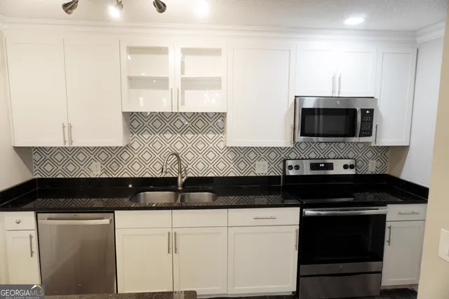 a close view of a stove a sink and dishwasher with kitchen island
