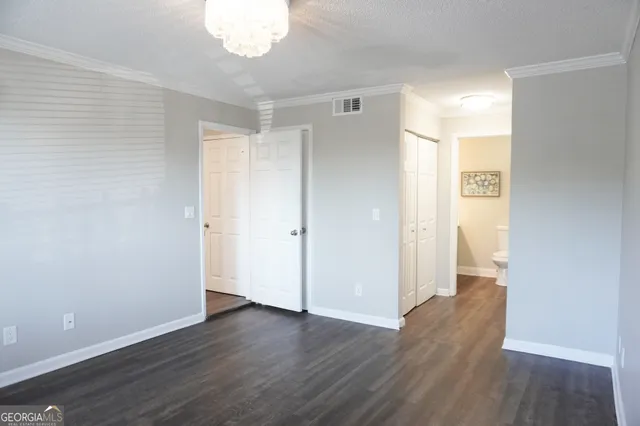 a view of an empty room with wooden floor
