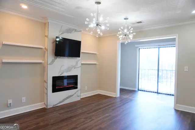 a view of a livingroom with a fireplace a chandelier and wooden floor