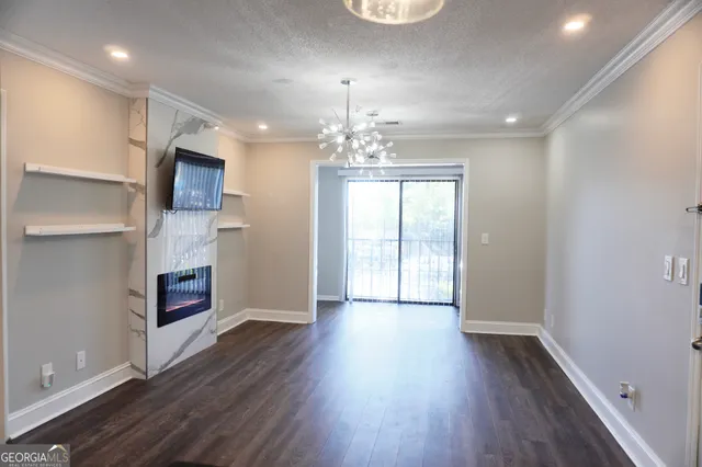 an empty room with wooden floor and chandelier