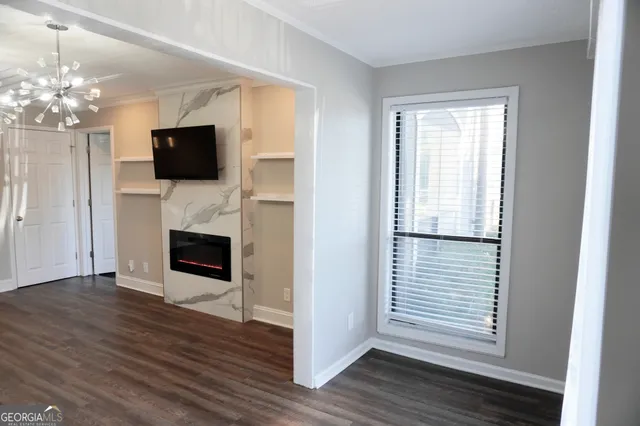 a view of a livingroom with a flat screen tv wooden floor and a fireplace