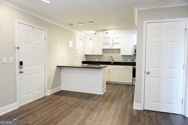 a kitchen with granite countertop white cabinets and black appliances