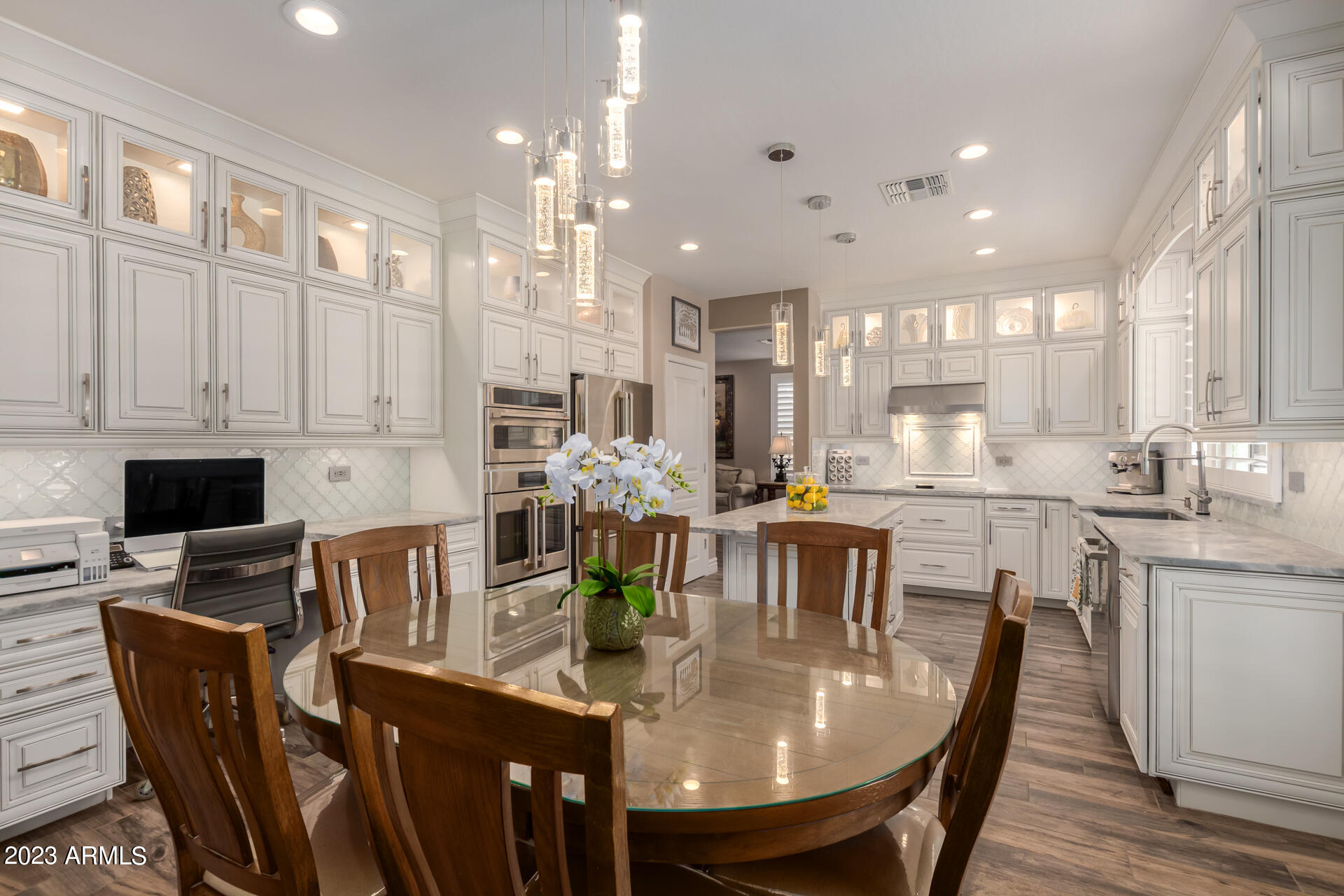 3416 West Montello Road Phoenix, AZ 85086 - Photo 19 of 71 a kitchen with stainless steel appliances granite countertop a dining table chairs and white cabinets