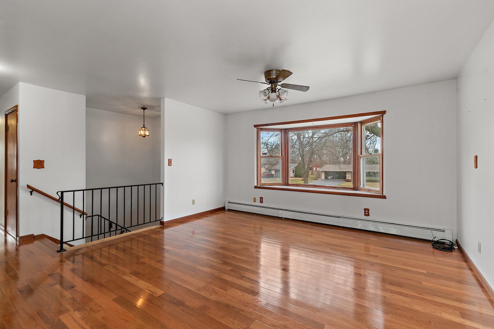 255 Deutsch Road Burlington, IL 60109 - Photo 3 of 26 a view of an empty room with a window and wooden floor