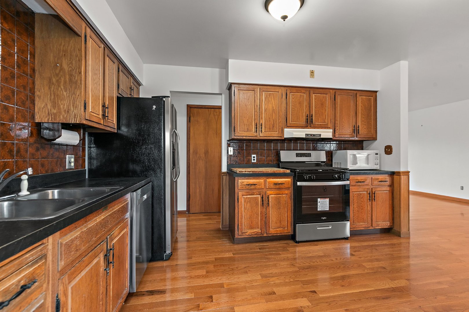 255 Deutsch Road Burlington, IL 60109 - Photo 9 of 26 a kitchen with granite countertop a refrigerator stove top oven and sink