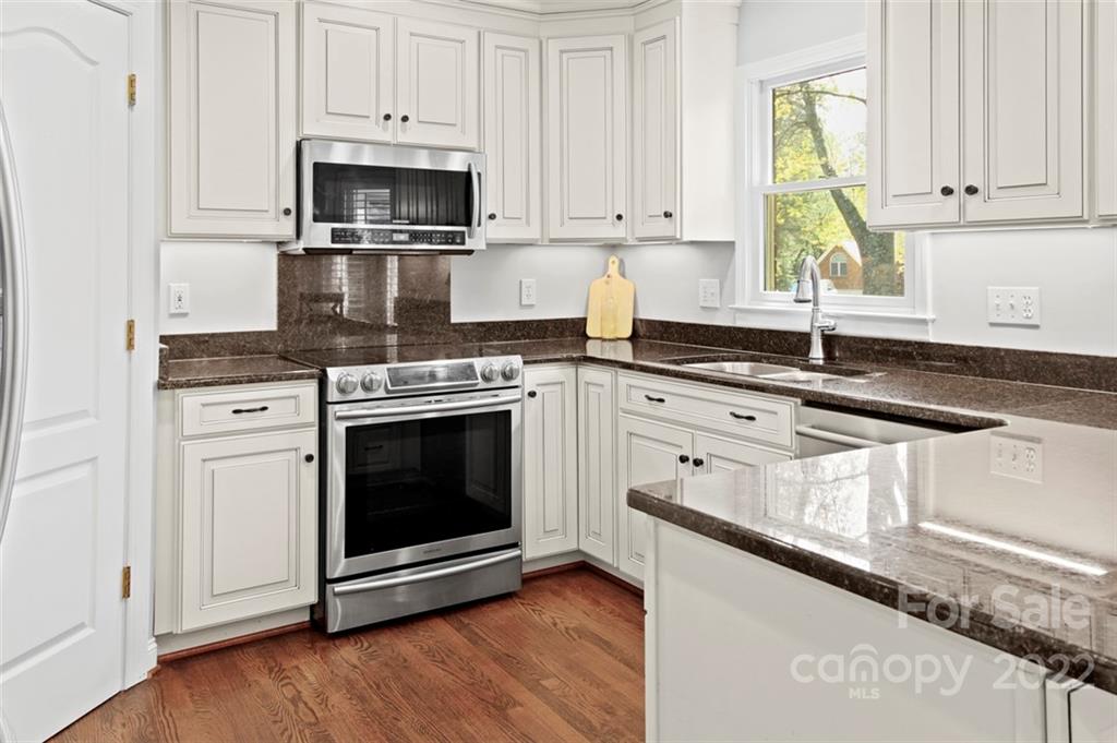 8438 Fairfield Forest Road Denver, NC 28037 - Photo 11 of 34 a kitchen with granite countertop white cabinets and appliances
