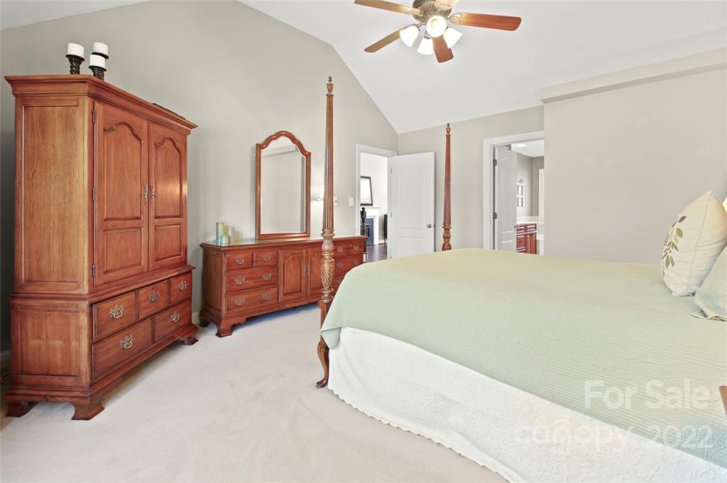 8438 Fairfield Forest Road Denver, NC 28037 - Photo 18 of 34 a spacious bedroom with a bed dresser and a chandelier