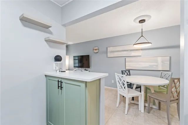 a kitchen with a dining table chairs and white cabinets