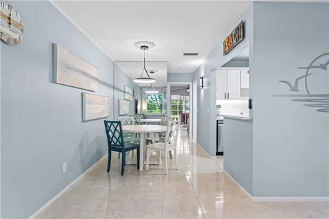 a dining room with kitchen island stainless steel appliances a table and chairs