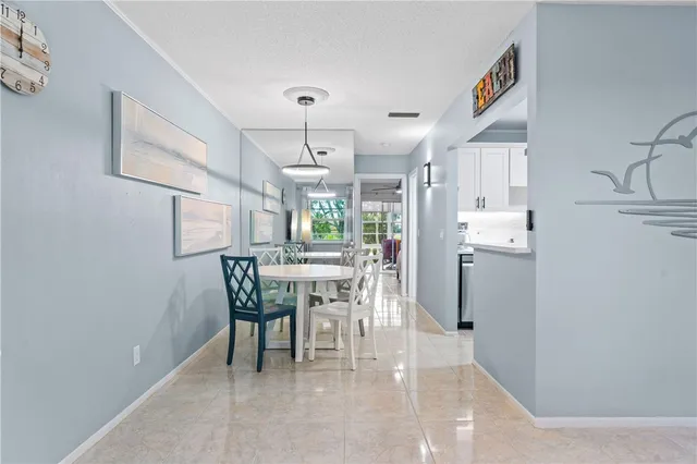 a dining room with kitchen island stainless steel appliances a table and chairs