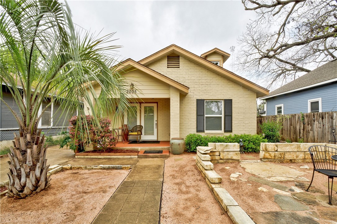 a front view of a house with a yard and outdoor seating