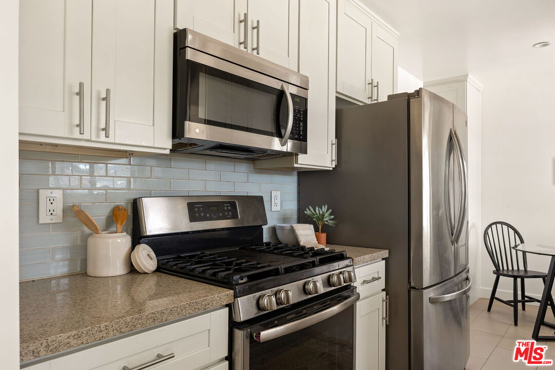 13610 Bracken Street Arleta, CA 91331 - Photo 12 of 23 a kitchen with stainless steel appliances granite countertop a stove microwave refrigerator and sink