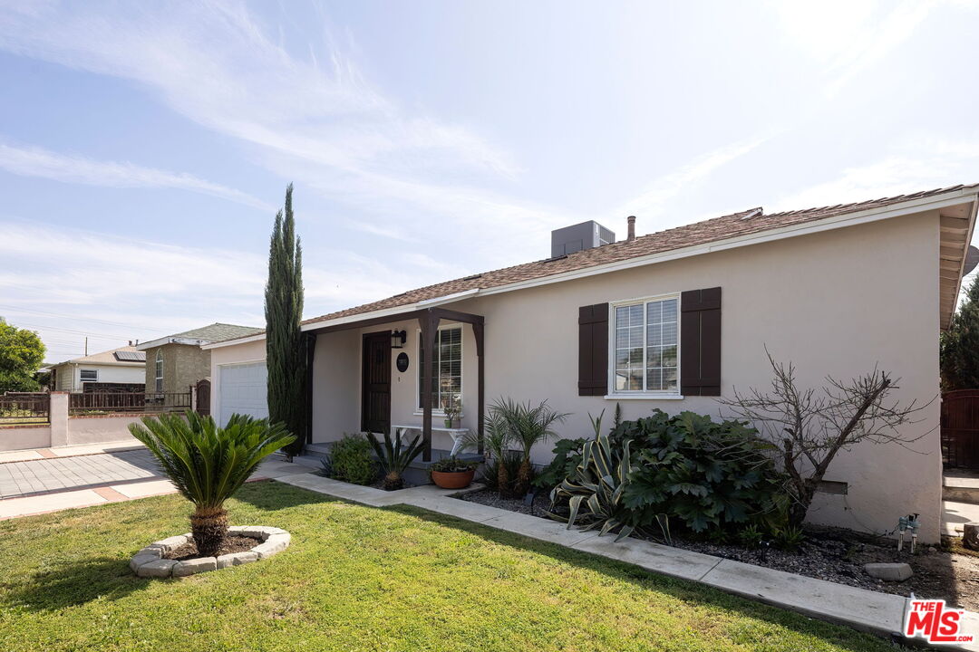 13610 Bracken Street Arleta, CA 91331 - Photo 3 of 23 a front view of a house with a yard and potted plants