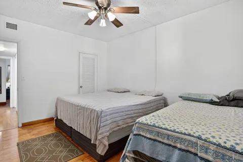 a bedroom with two beds and wooden floor