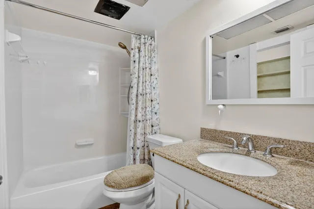 a bathroom with a granite countertop sink toilet and shower