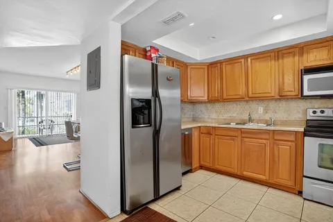 a kitchen with stainless steel appliances granite countertop a refrigerator a sink and a microwave